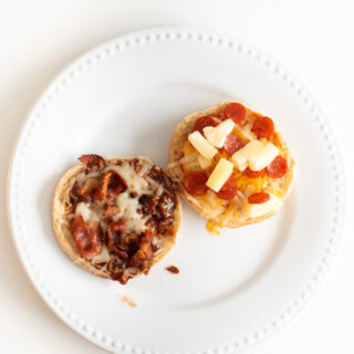 A BBQ bacon and a Hawaiian English muffin pizza on white dinner plate.