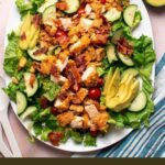 Pinterest graphic with text and photo of blt salad with crispy chicken on white platter.