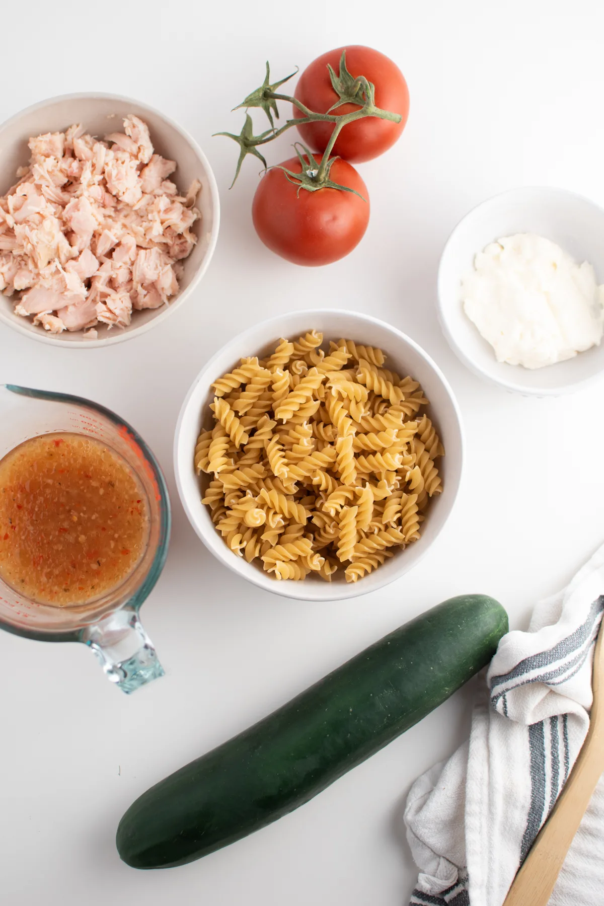 Rotini pasta salad ingredients including rotini, mayo, dressing, chunk chicken and tomatoes.