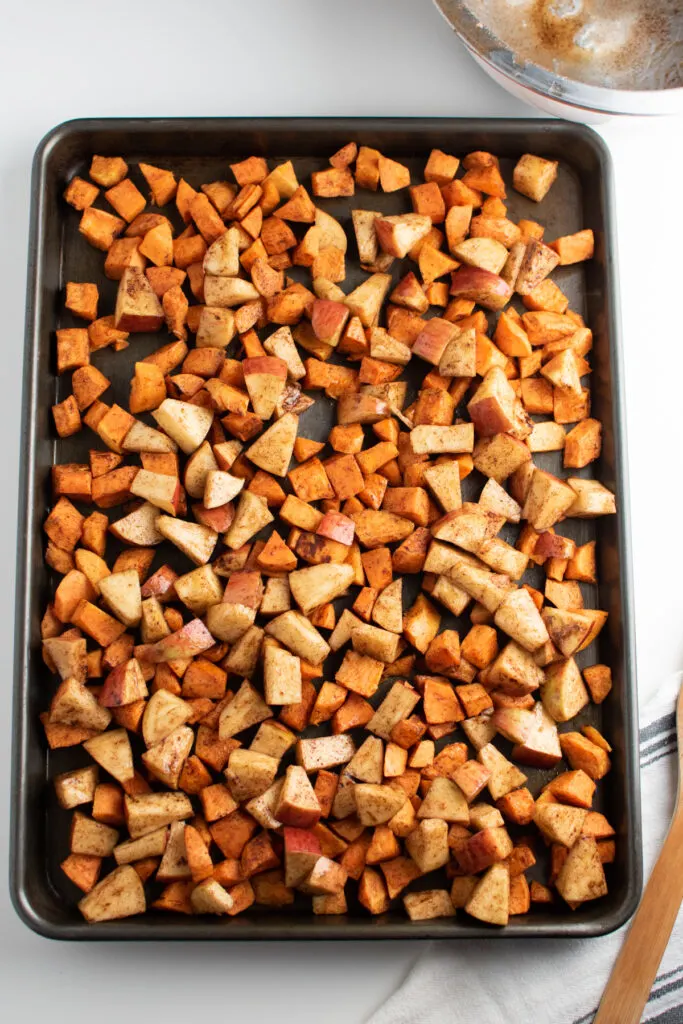 Roasted sweet potatoes and apples on a sheet pan.