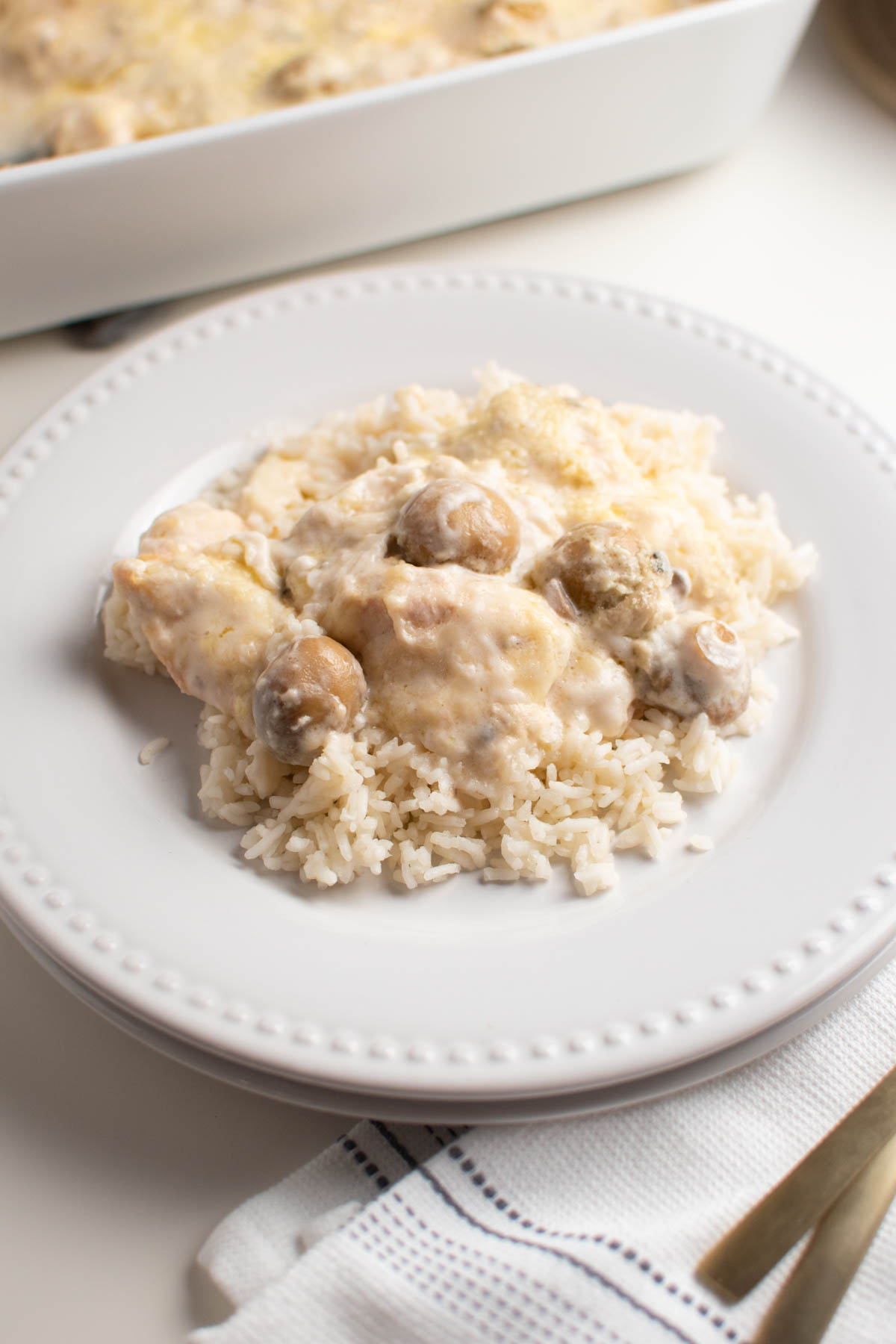 Swiss cheese chicken and mushrooms on a white plate.