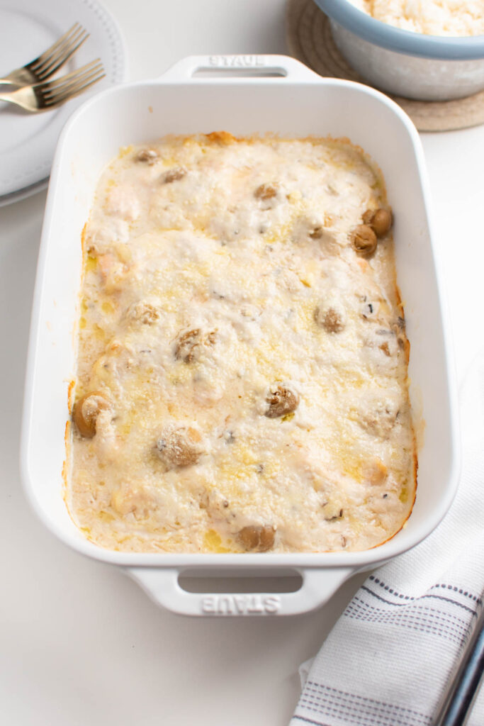 Swiss chicken casserole in baking dish with blue and white kitchen towel.