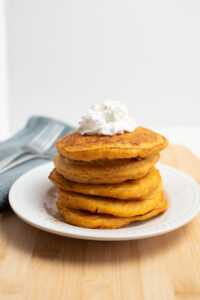 Pumpkin pancakes with pancake mix stacked on a plate.