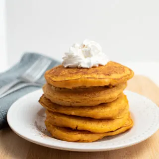 Pumpkin pancakes with pancake mix stacked on a plate.