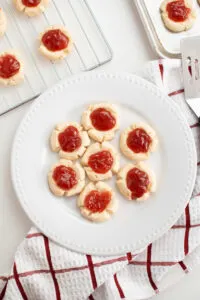 Jam filled cookies on a white plate.