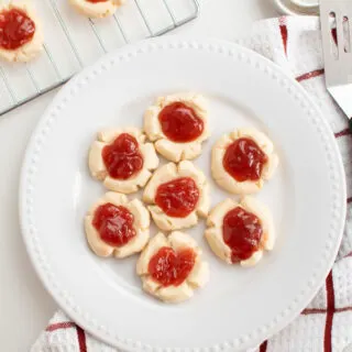 Jam filled cookies on a white plate.