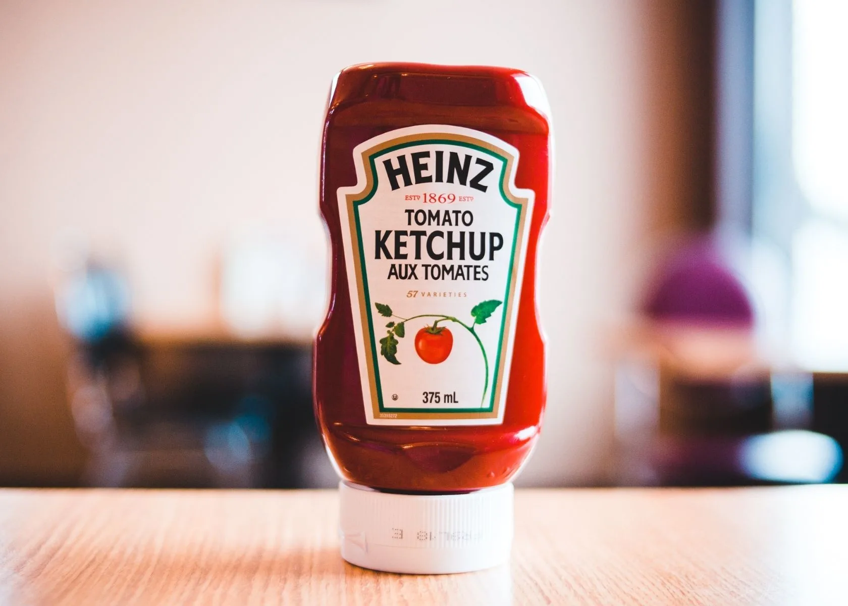 Heinz ketchup bottle on wood table in a restaurant.