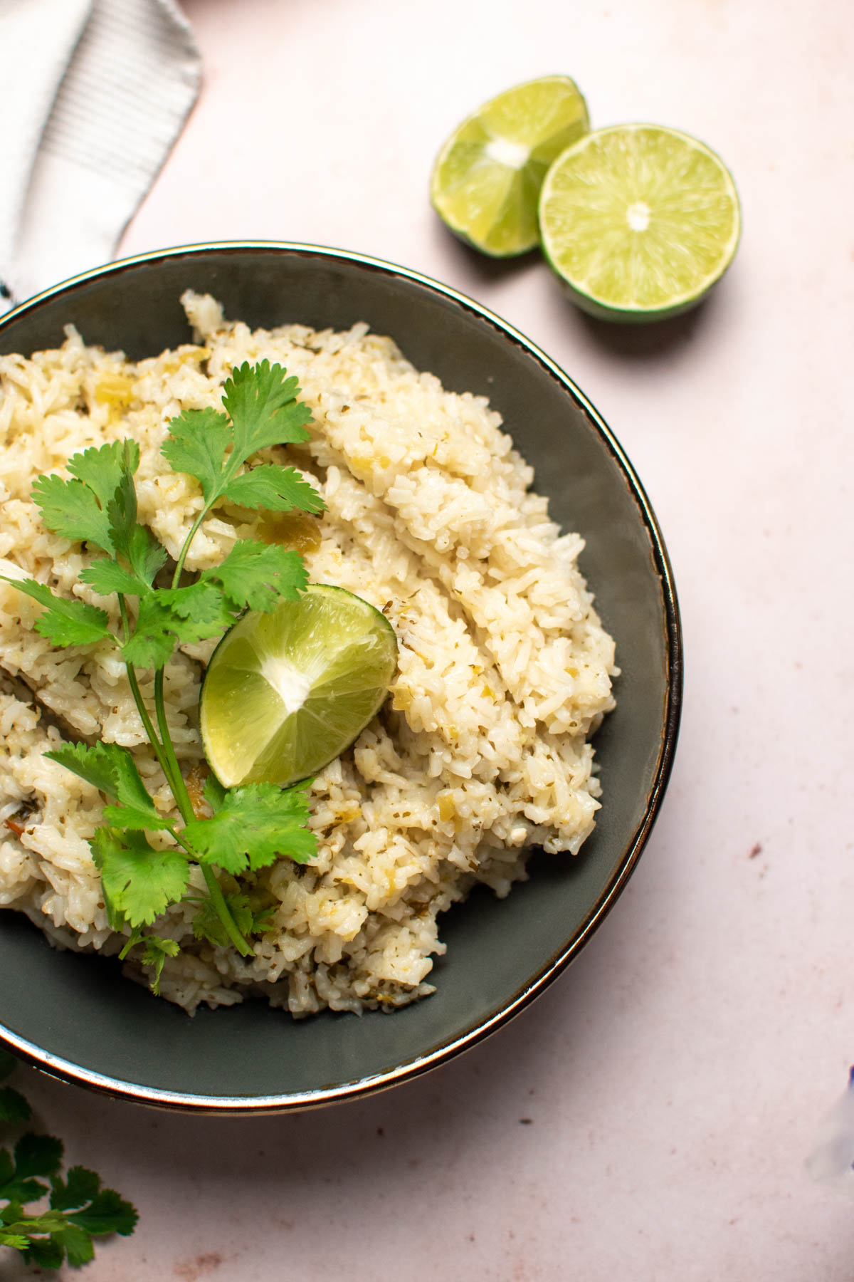 Cilantro lime rice with cilantro and lime garnish in gray bowl.