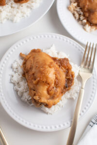 Crock Pot BBQ pineapple chicken on white plate of rice with silver fork.