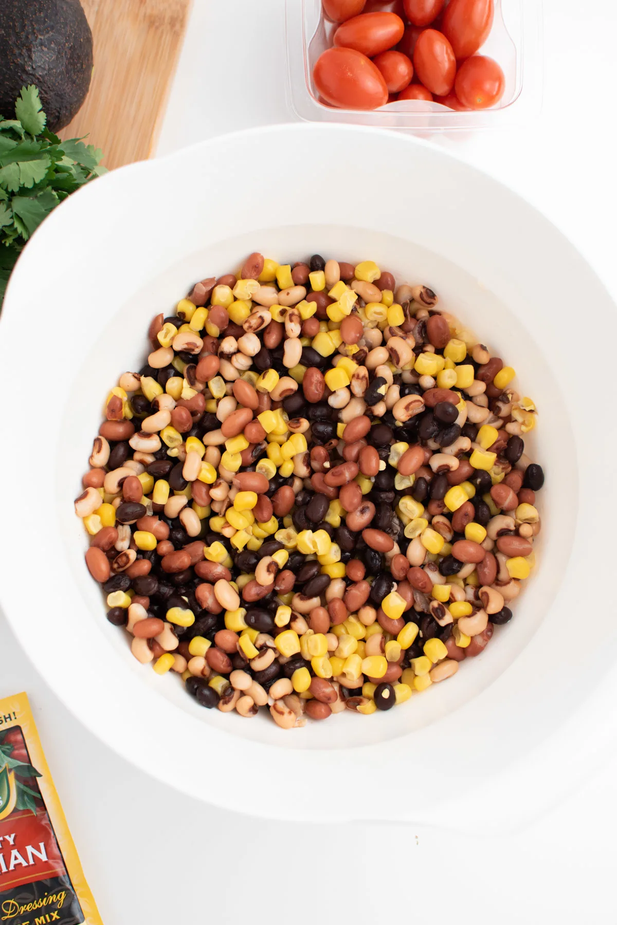 Rinsed beans and corn in large white mixing bowl to make cowboy party dip.