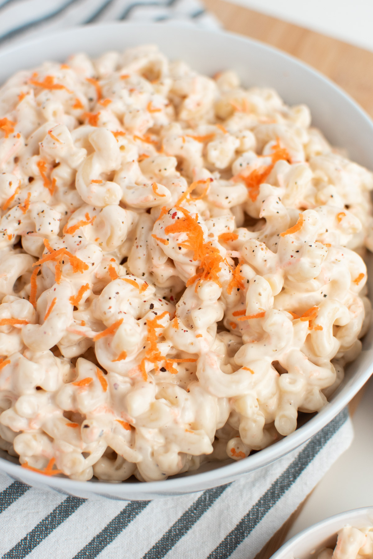 Close up of Hawaiian mac salad with ground pepper and shredded carrots.