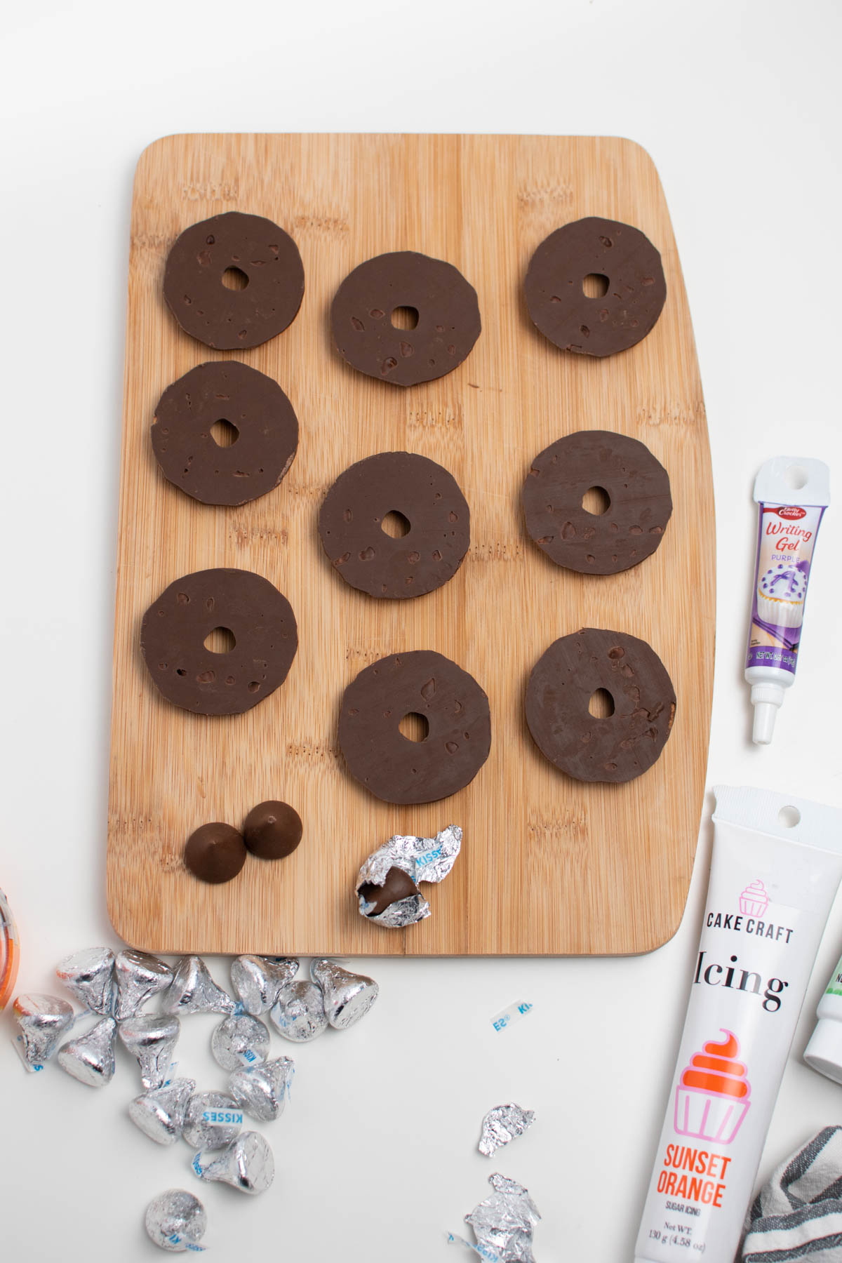 Nine fudge stripes cookies laying upside down on wood cutting board.