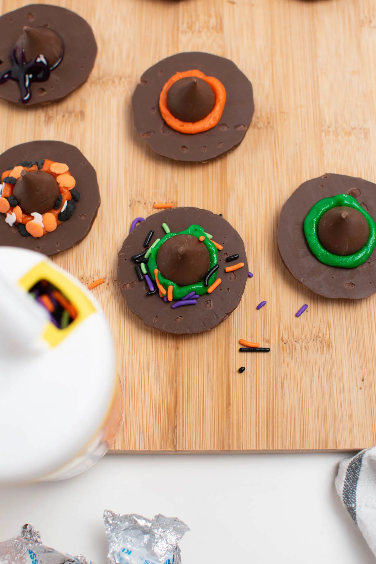Halloween sprinkles on witch hat cookie and wood cutting board.