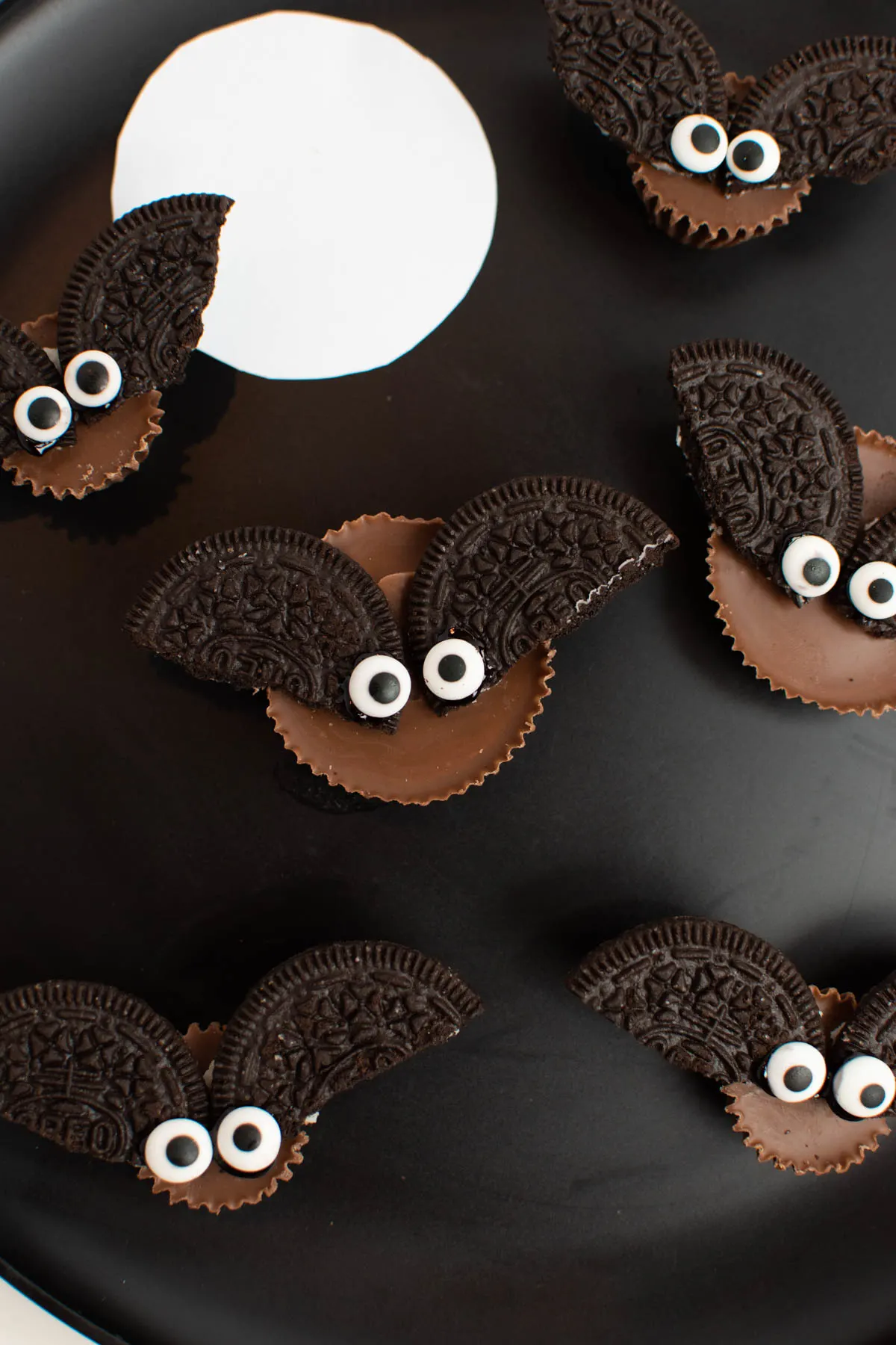 Close up of Oreo bats on black plate with white moon.