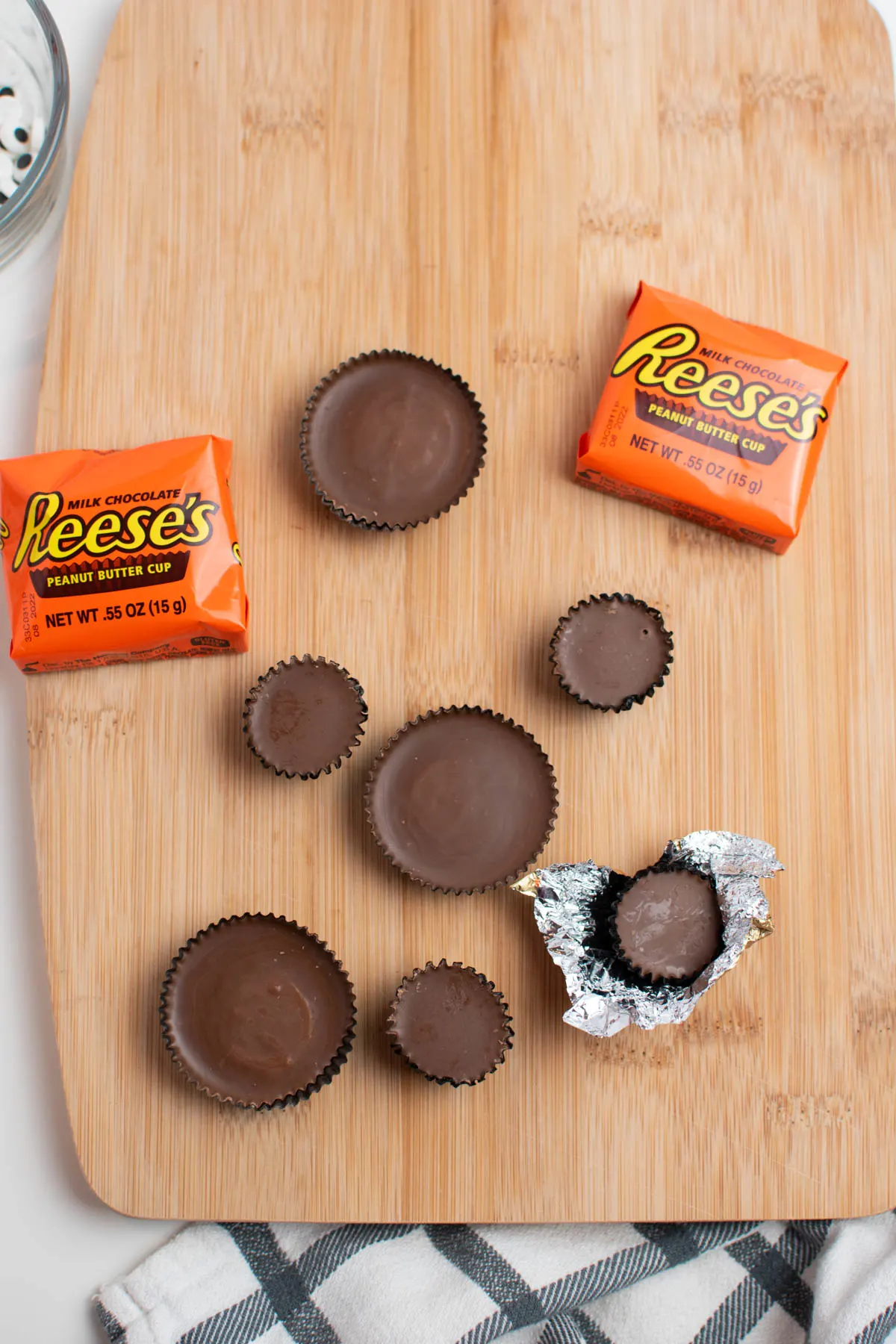 Unwrapped Reese's snack and miniature cups on wood cutting board.
