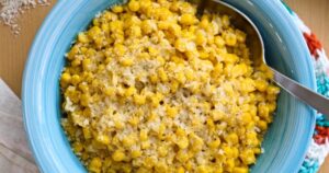 Brown butter parmesan corn with metal spoon