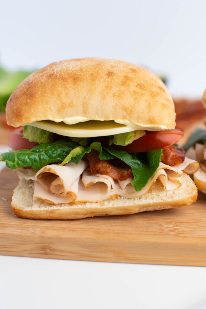 Close up of turkey bacon avocado sandwich on ciabatta roll.