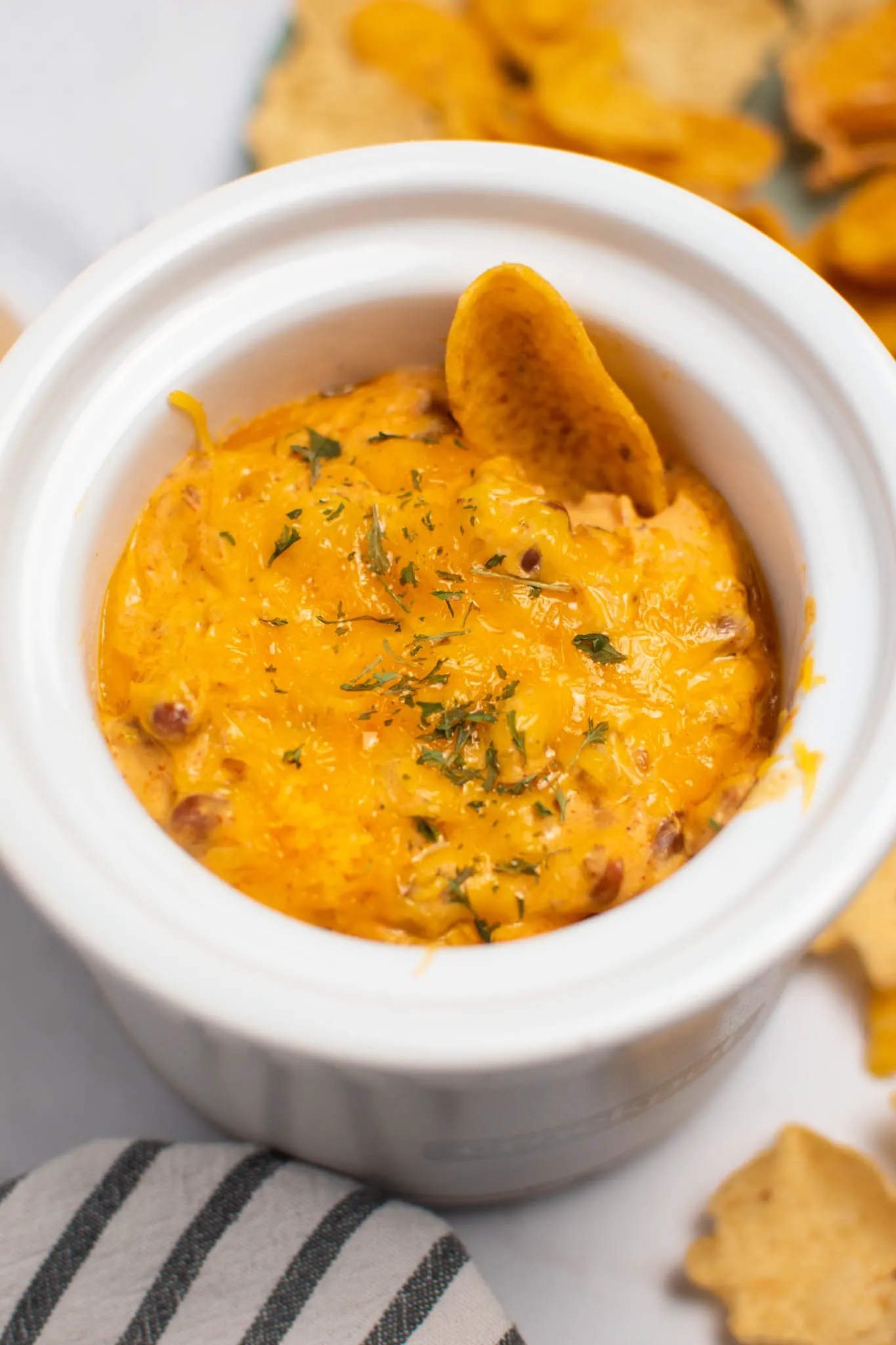 Single Frito scoop chip in small Crock Pot of chili cheese dip.