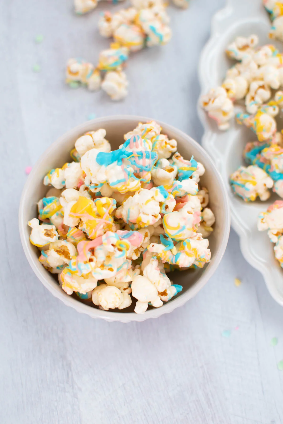 Small bowl of bunny bait popcorn colored with pink, blue, and yellow candy melts.