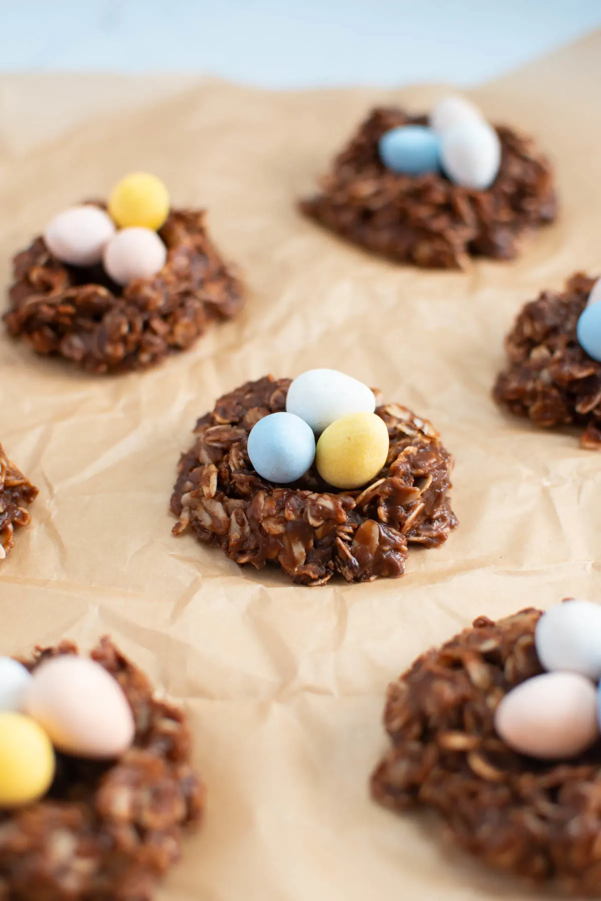 Several no bake birds nest cookies on crumpled parchment paper.