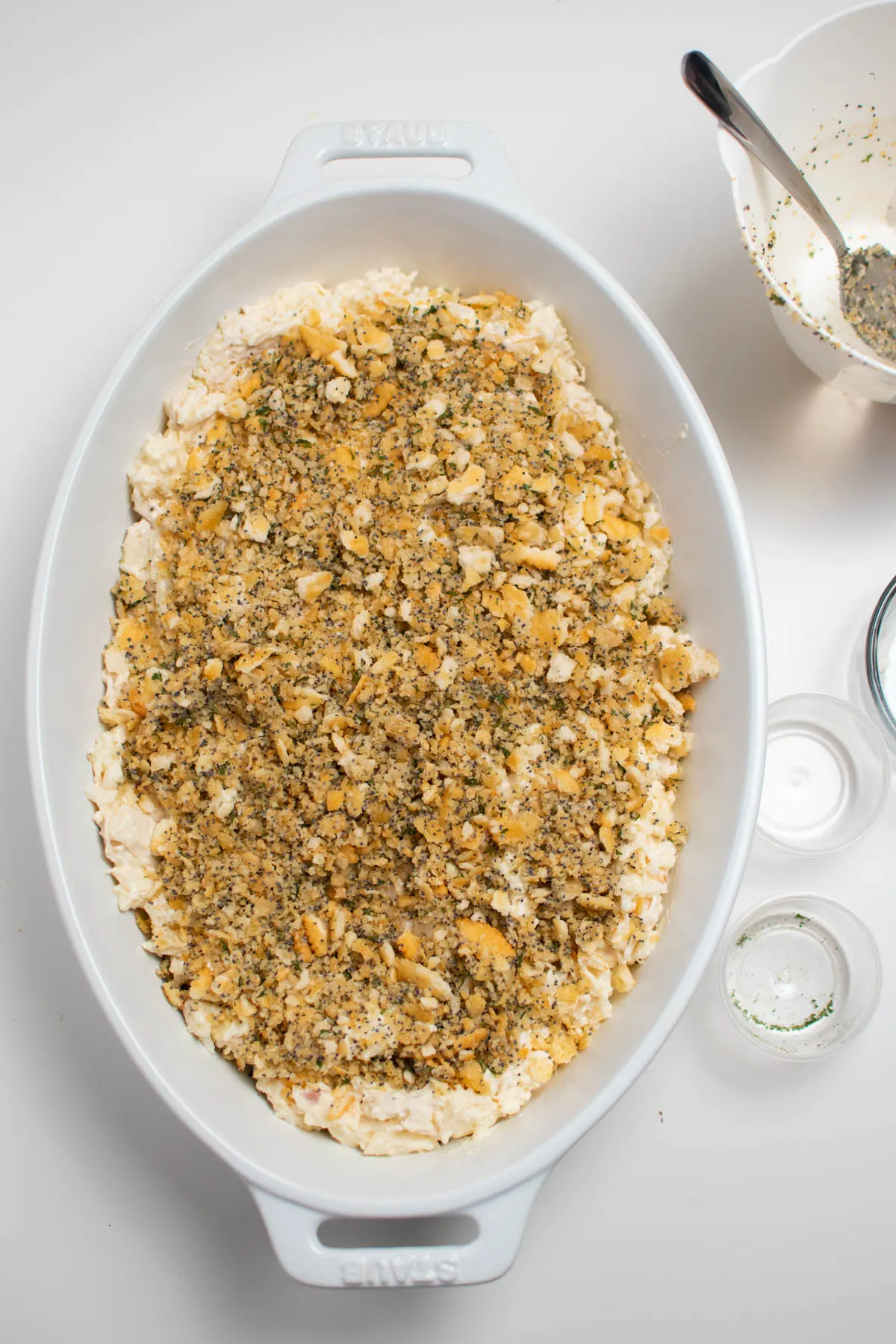 Unbaked chicken poppy seed casserole in white baking dish on white table.