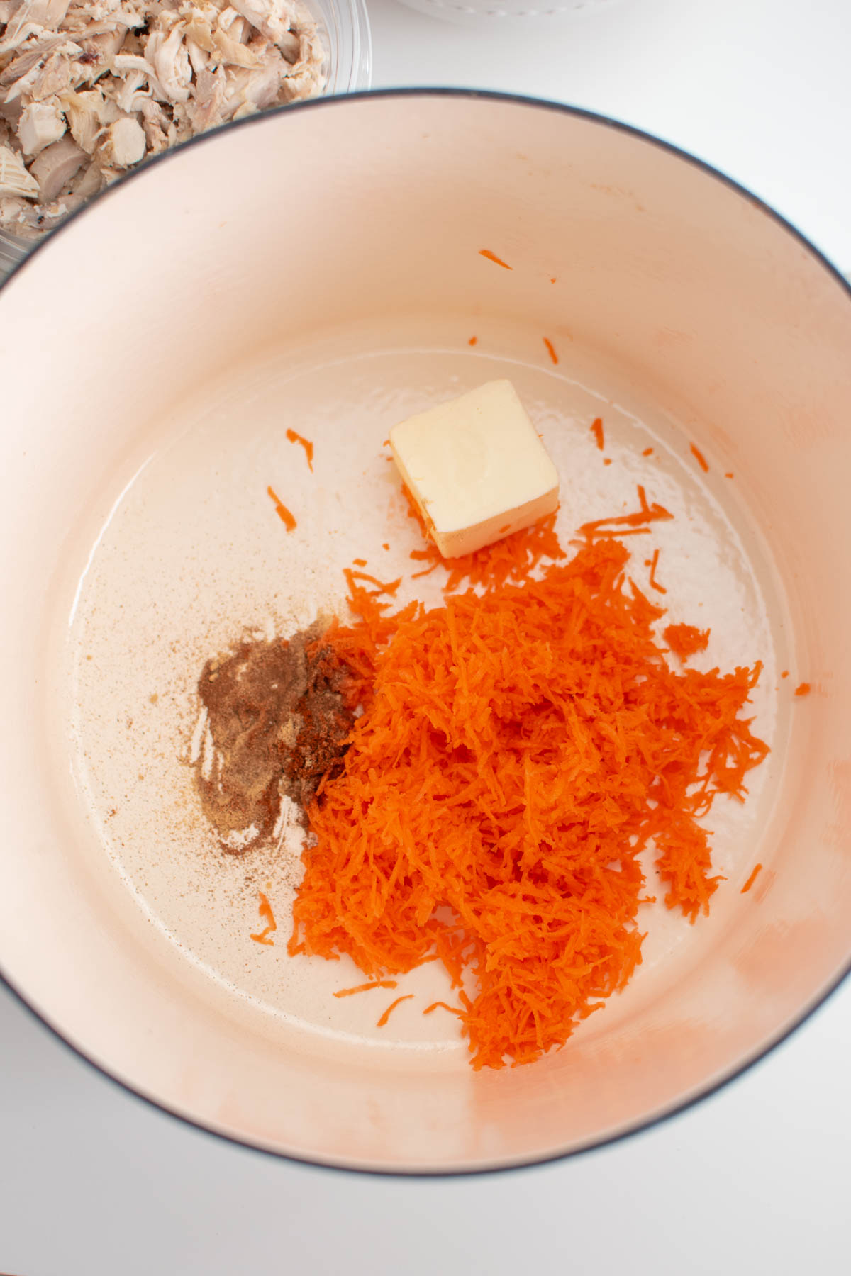 Shredded carrot, butter, and spices in large dutch oven.