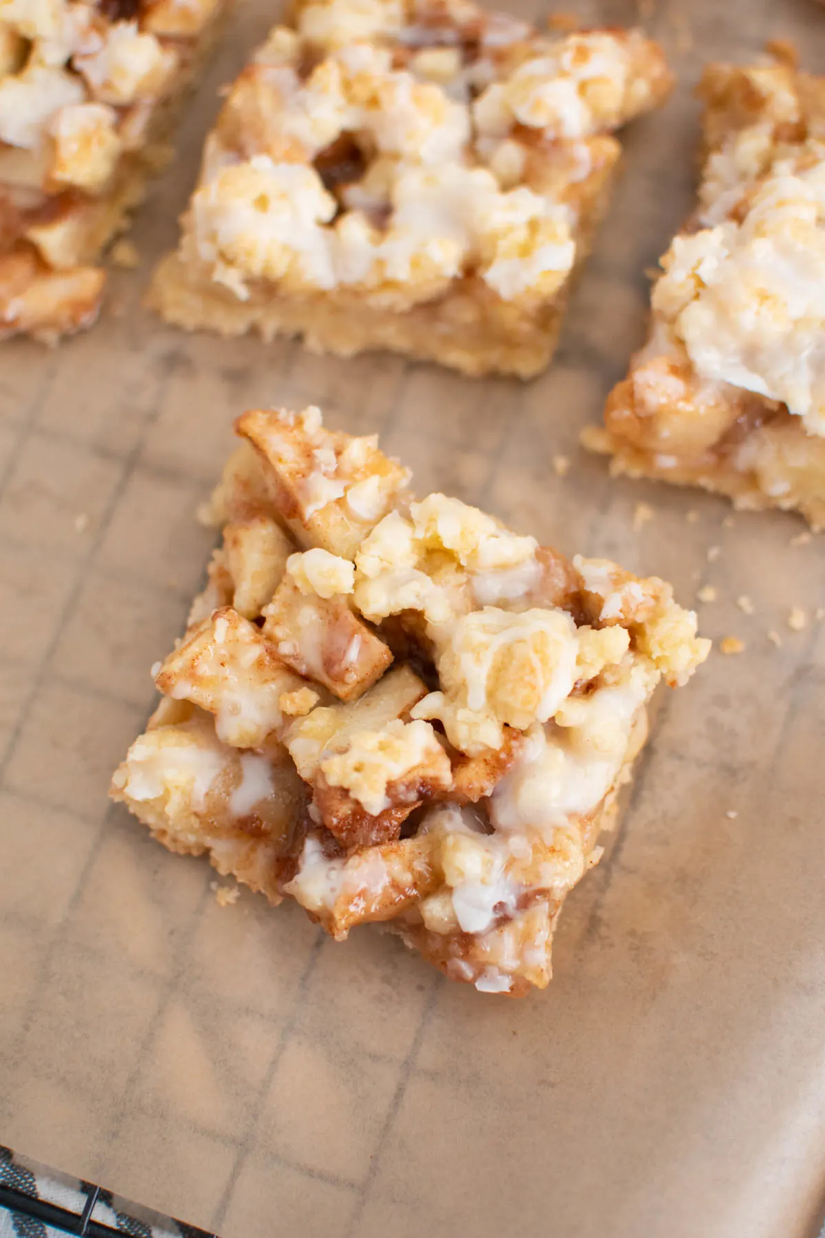 Apple pie bars on parchment paper lined baking rack.