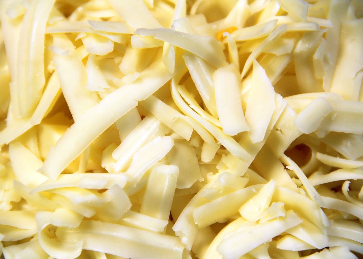 Close up view of large pile of white shredded Monterey Jack cheese.
