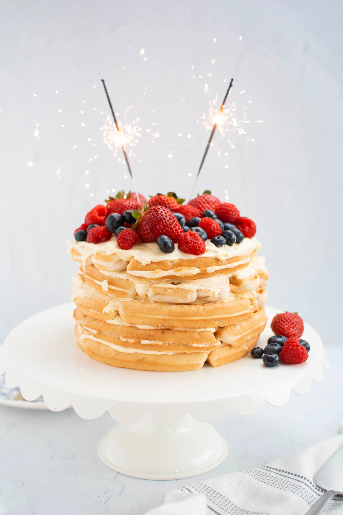Patrotic berry waffle cake with pudding filling and sparklers on top.