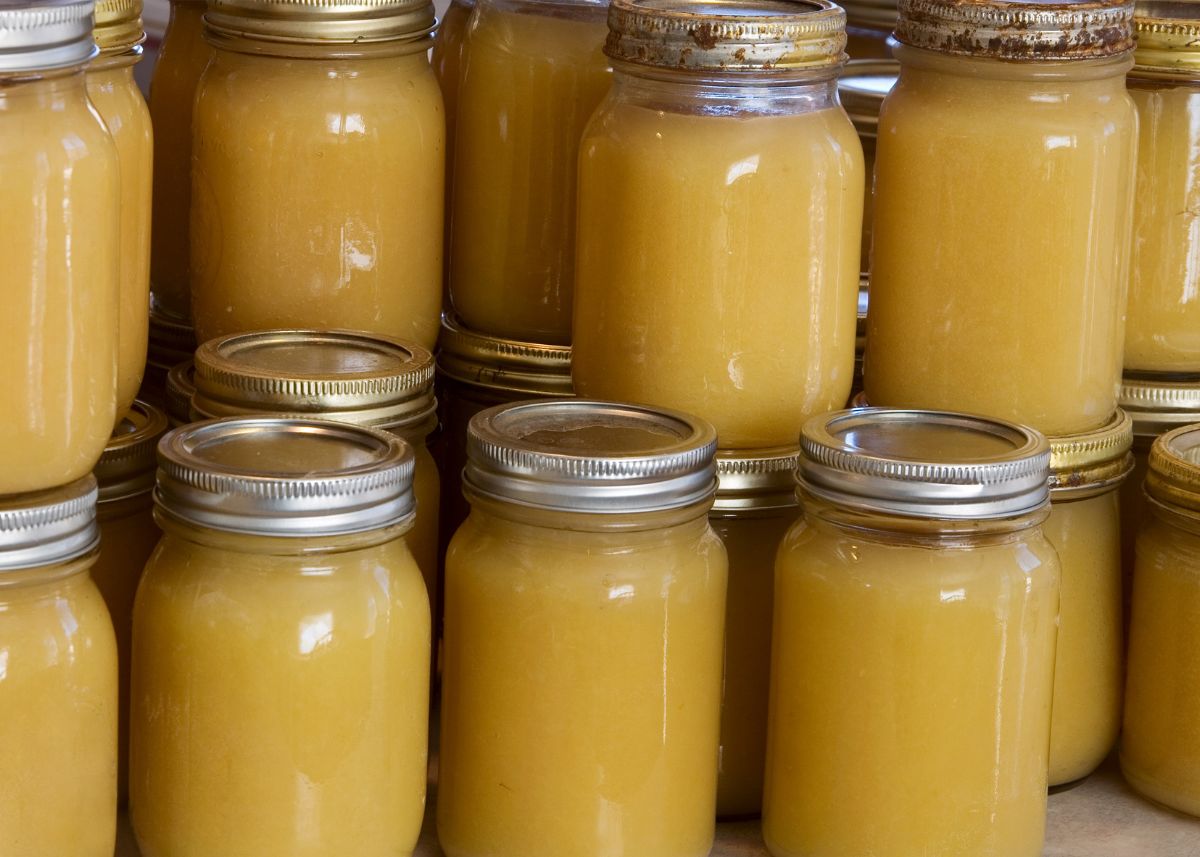 Several glass canning jars full of applesauce all stacked together.