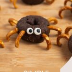 Pinterest graphic with text and photo of spider donuts on wood cutting board.