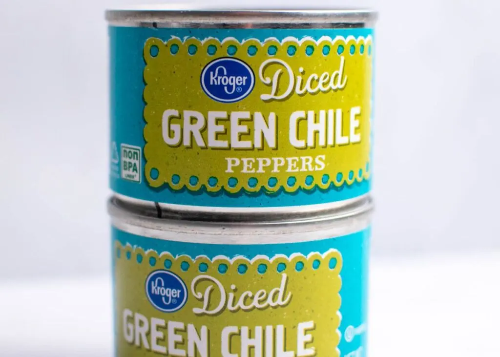 Close up on two stacks cans of diced green chile peppers.
