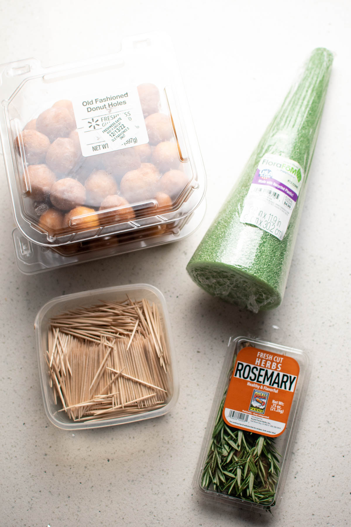 Ingredients for a donut hole tree on counter including foam cone, toothpicks, and donuts.