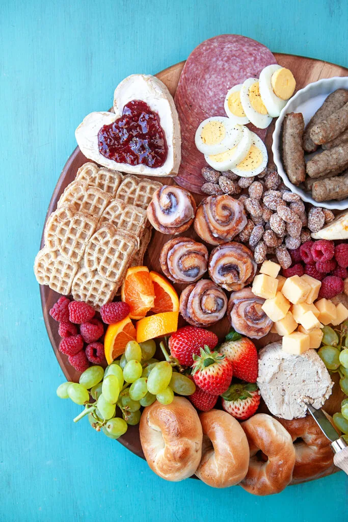 Breakfast charcuterie board with fruit, cheese, waffles, eggs, and more.