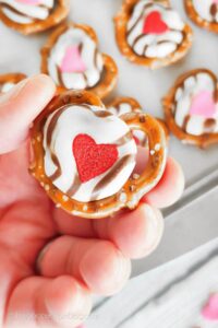 Valentine's day pretzel treats with melted white chocolate kisses and candy hearts.