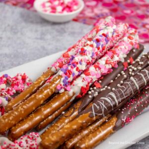 Think pretzel rods dipped in chocolate and pink, red, and purple sprinkles.