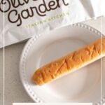 Pinterest graphic with text and an Olive Garden breadstick on a white plate.