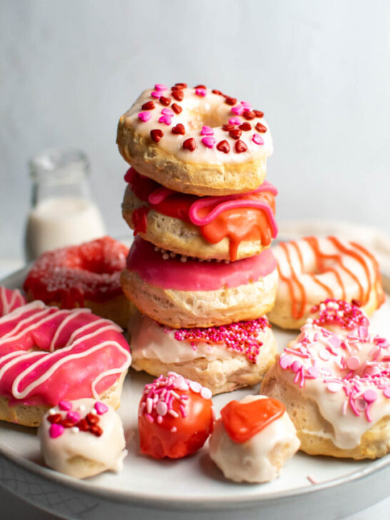 Stack of decorated air fryer Valentine's Day donuts on cake stand.