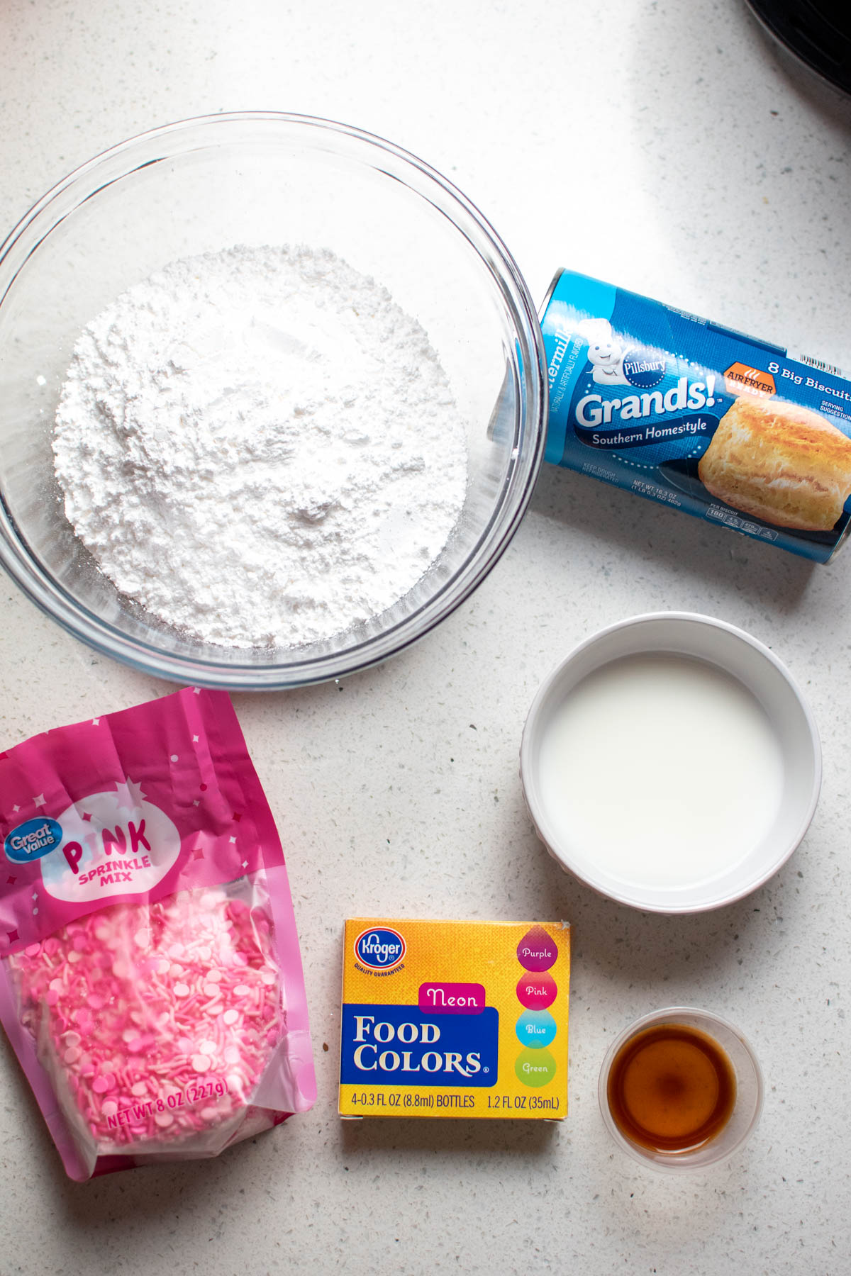 Ingredients for Valentine's Day air fryer donuts on counter including canned biscuits and pink sprinkles.