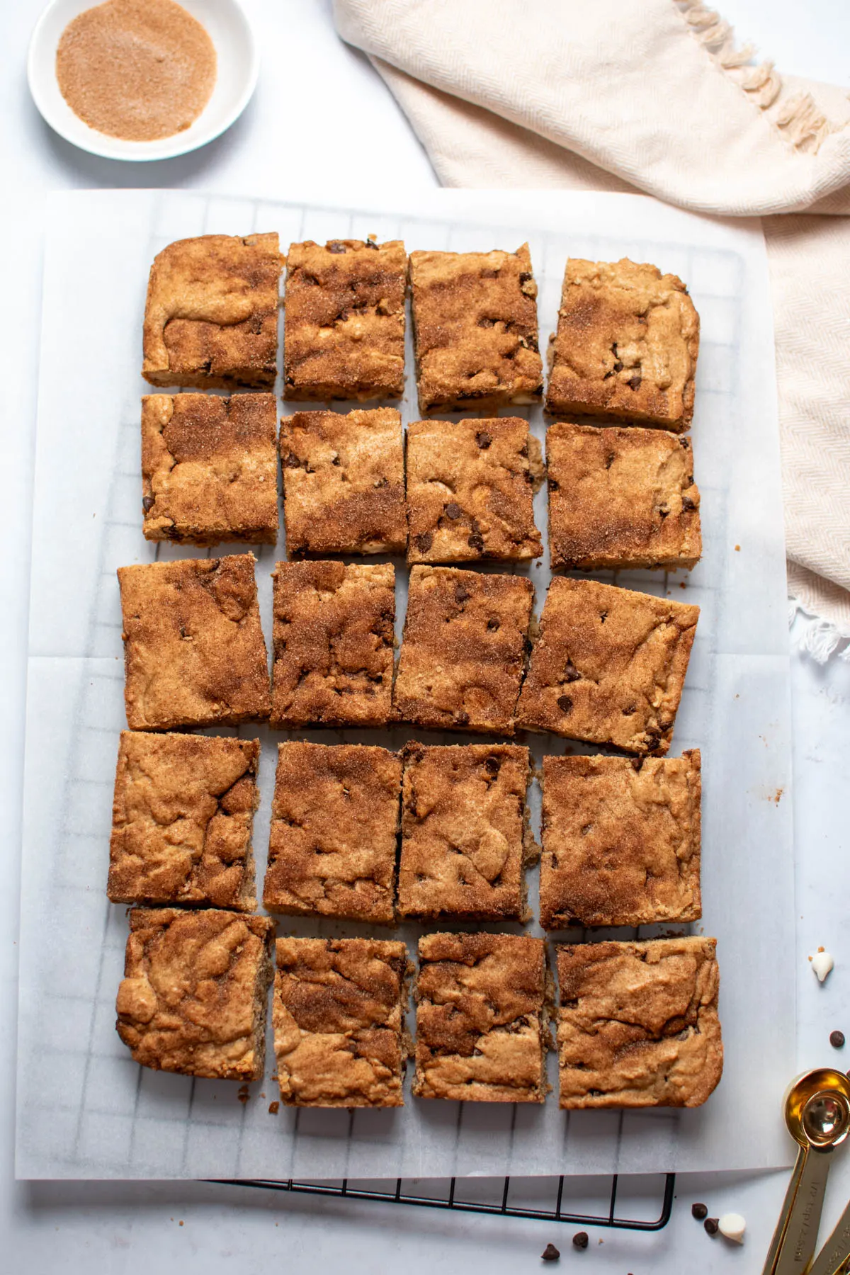20 cinnamon chocolate chip blondies arranged on parchment paper as they are in the pan.