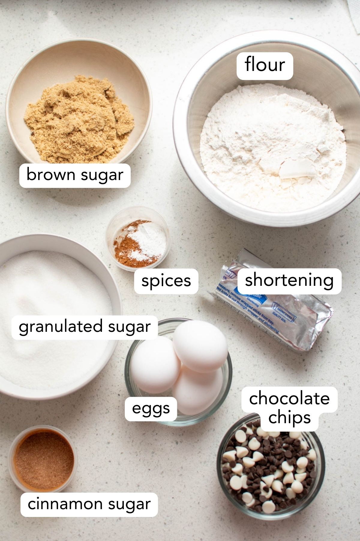 Labeled photo with different bowls of ingredients for cinnamon chocolate chip blondies.