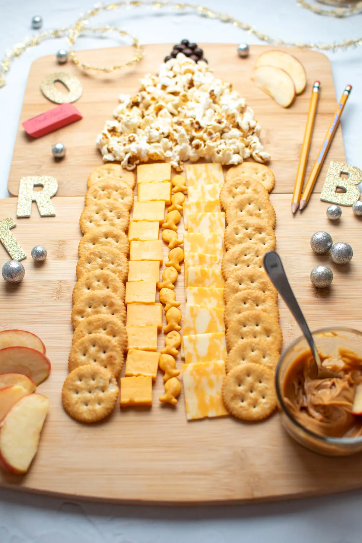 Back to school charcuterie board with cheese, crackers, popcorn, and raisins.