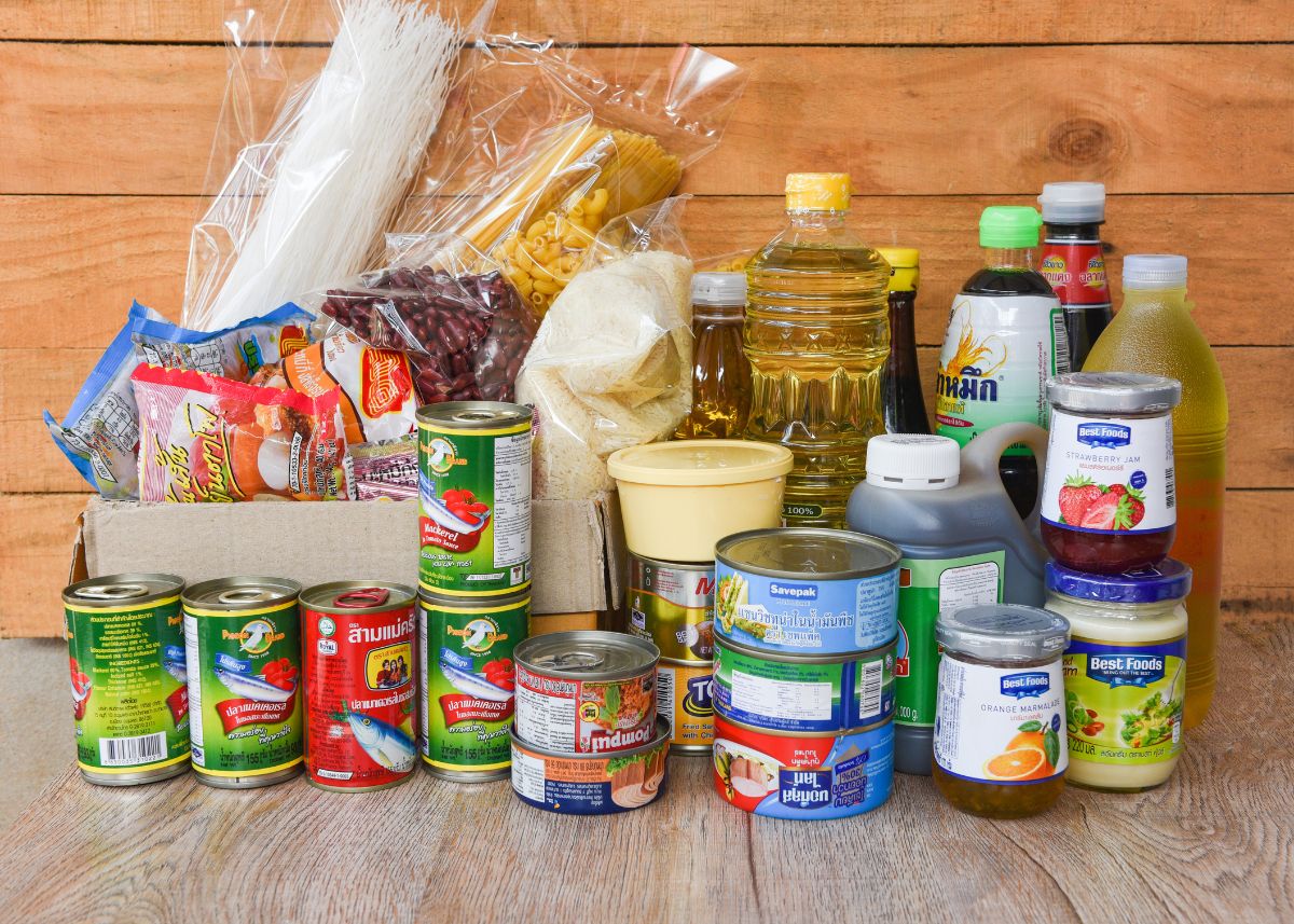 Canned foods, dried foods, oils, and non-perishable foods stacked on the floor.