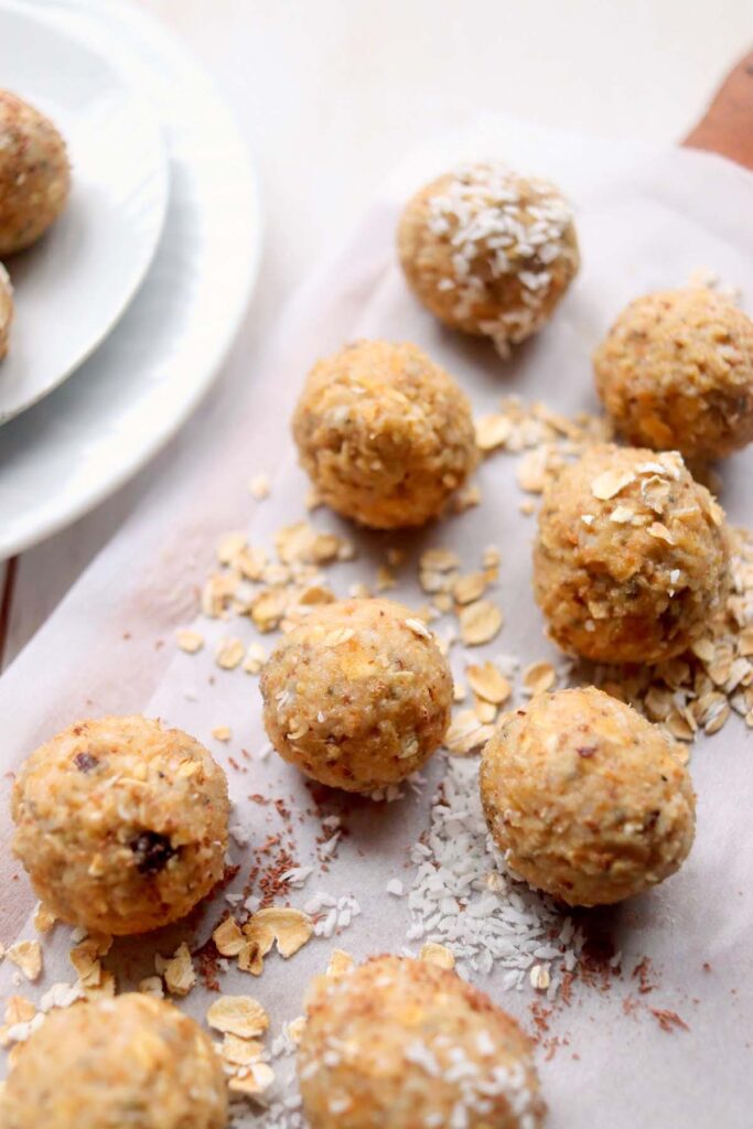 Energy bites on parchment paper sprinkled with oats.