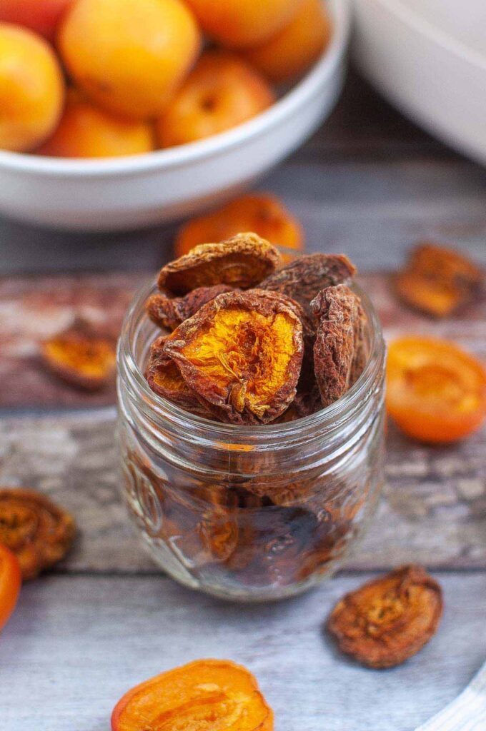 Dehydrated apricot chips in a short mason glass jar.