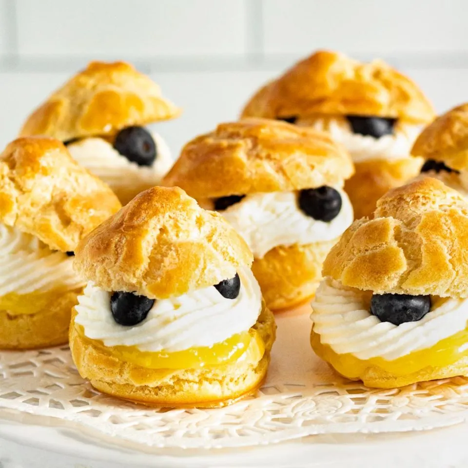 Lemon cream puffs with lemon curd, white cream, and fresh blueberries.