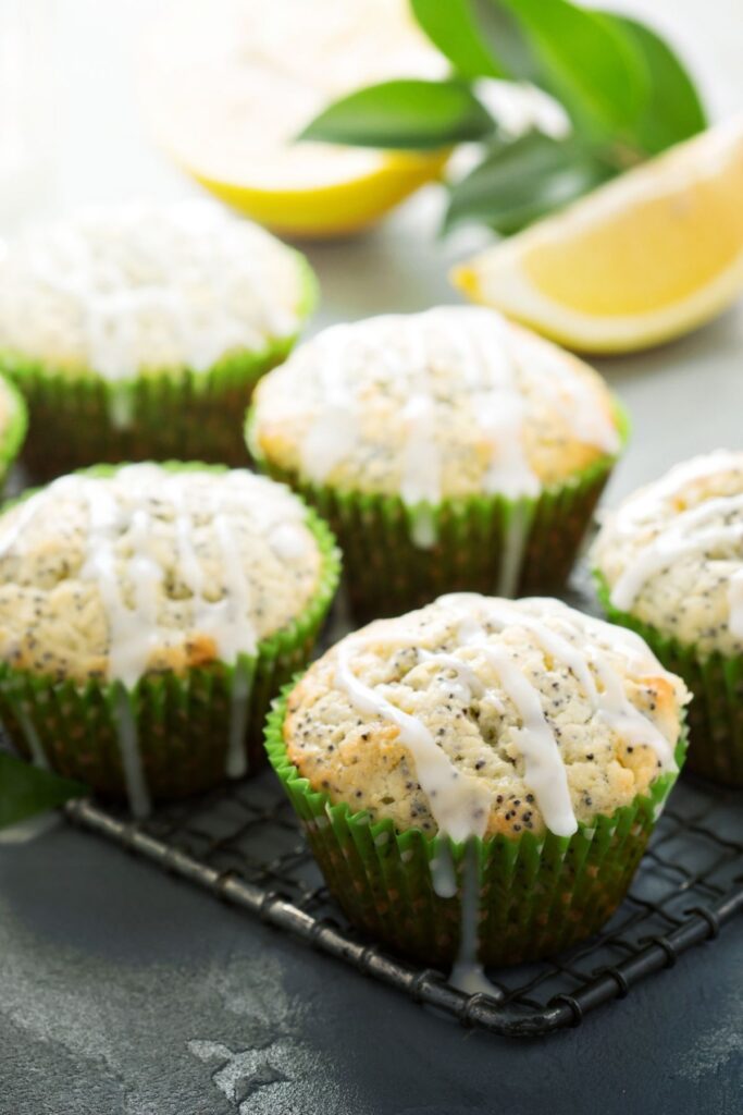 Lemon poppy seed muffins in green cupcake liners with white glaze.