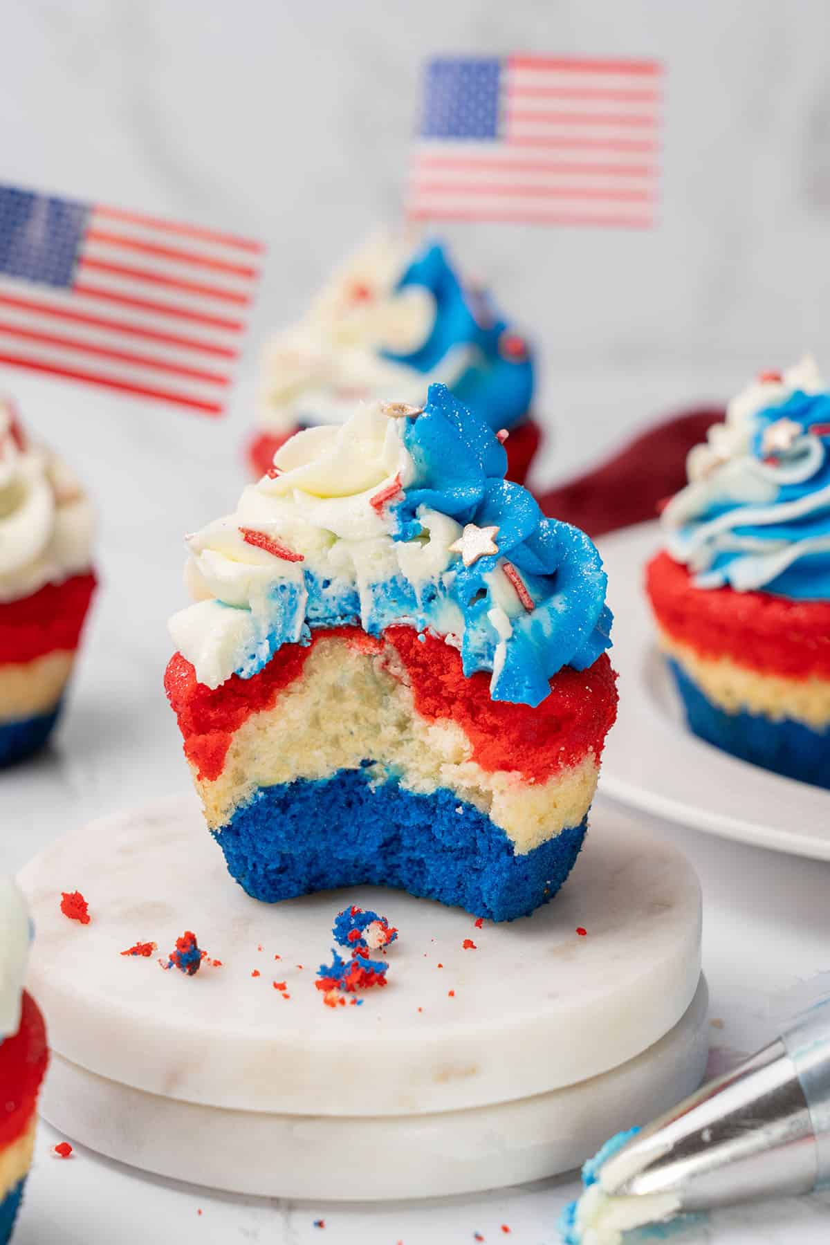 Red, white, and blue layered cupcakes with white and blue frosting.