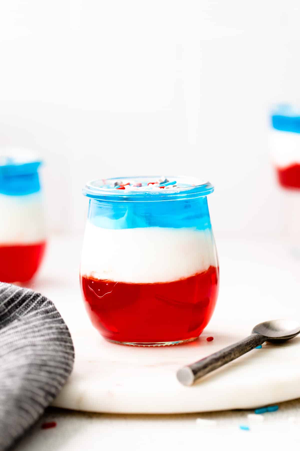 Red, white, and blue layered jelly in a glass jar.