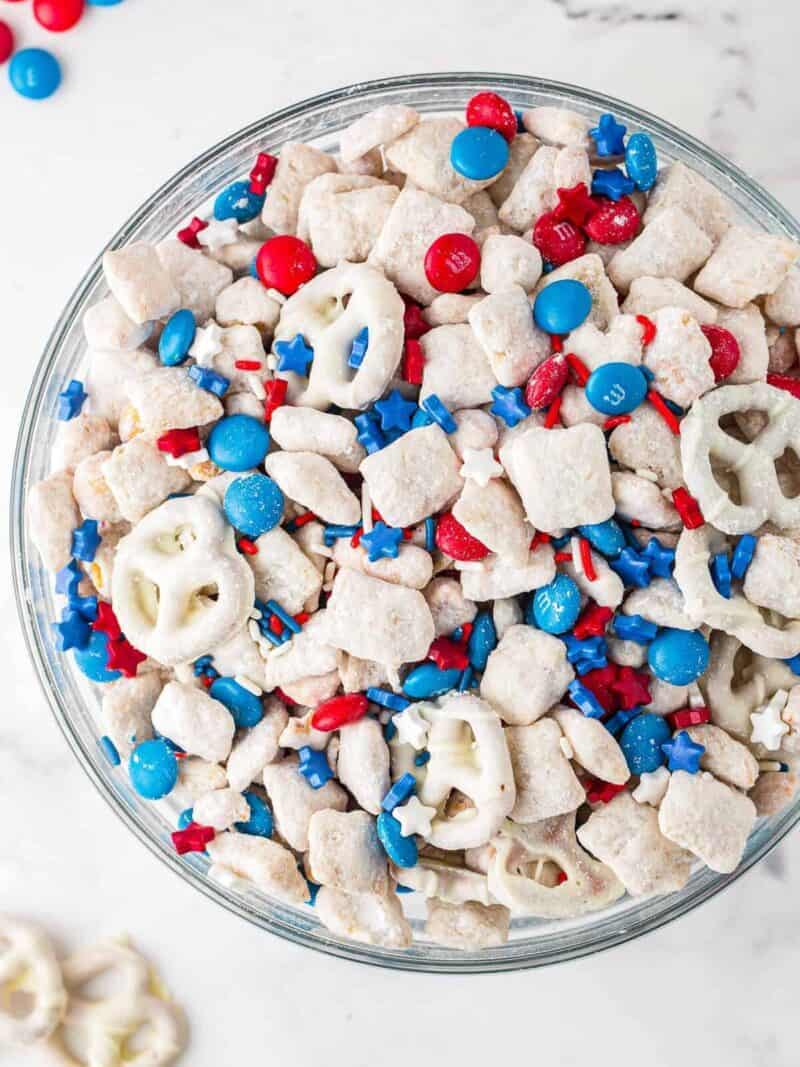 Red, white, and blue puppy chow snack mix with M&Ms and pretzels.